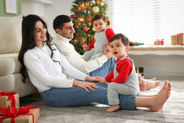 Ebeveynler ve onların sevimli ikiz bebekleri evde. Noel sezonu