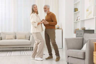 Güzel yaşlı çift evde dans ediyor.