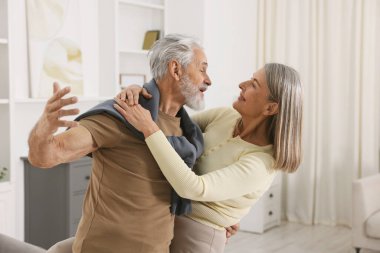 Güzel yaşlı çift evde dans ediyor.