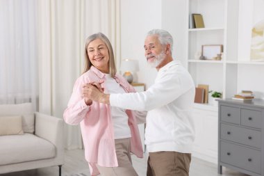 Güzel yaşlı çift evde dans ediyor.