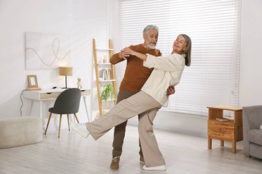 Güzel yaşlı çift evde dans ediyor.