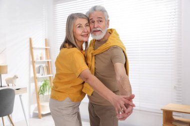 Güzel yaşlı çift evde dans ediyor.