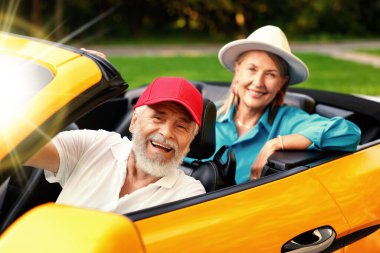 Kıdemli çift güneşli bir günde Cabriolet 'e binmekten zevk alıyor.