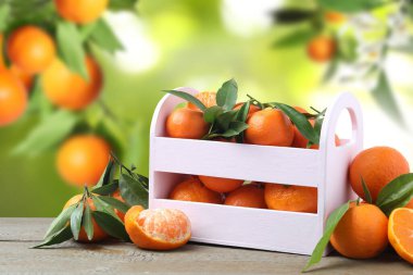 Tahta masada sandıkta taze, sulu mandalinalar.