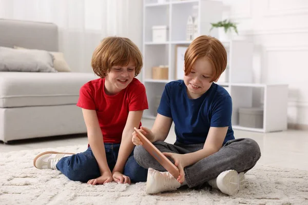 Evde tabletleri olan sevimli kardeşler.