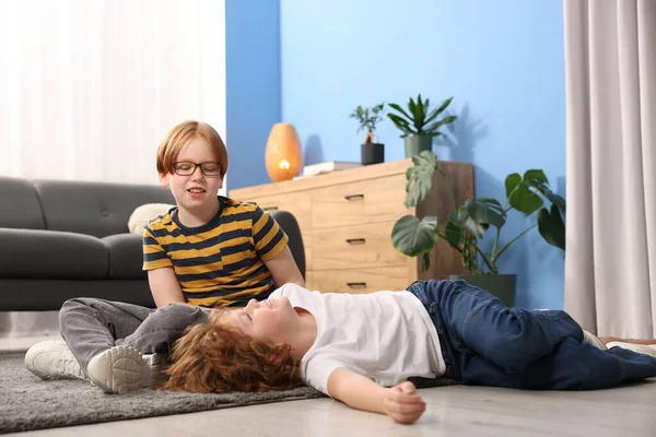 İki kardeş evde yerde birlikte vakit geçiriyorlar.