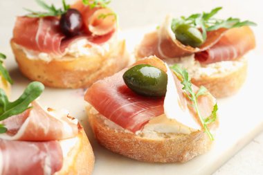 Krem peynirli, jambonlu, zeytinli ve roka soslu nefis bruschettalar.