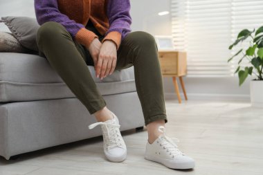 Pouf 'un üzerinde şık ayakkabılar giyen bir kadın, yakın plan. Metin için boşluk