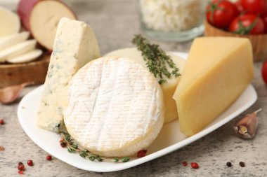 Gri masada servis edilen farklı taze süt ürünleri.