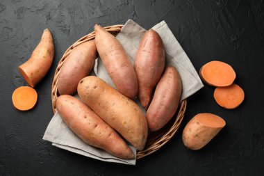 Siyah desenli masada çiğ patates, düz uzanmış.