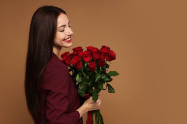 Sevgililer Günü. Bej arka planda gül buketi olan güzel bir kadın. Metin için boşluk