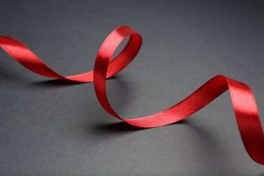 Gri arkaplanda güzel kırmızı kurdele, yakın plan