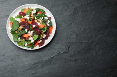 Siyah masada pancar, ıspanak, peynir, ceviz ve havuç ile nefis bir salata. Metin için boşluk