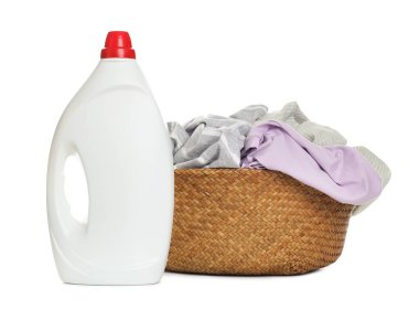 Çamaşır sepetinin içinde giysiler ve beyaza izole edilmiş bir şişe deterjan.