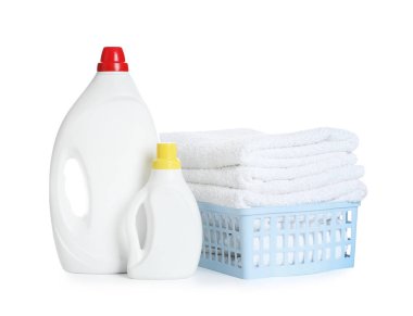 Çamaşır sepeti, yumuşak havlular ve beyaza izole edilmiş deterjan şişeleri.