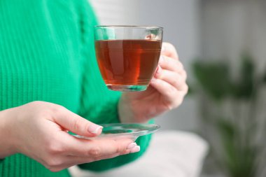 Bir fincan çay tutan kadın, yakın plan.