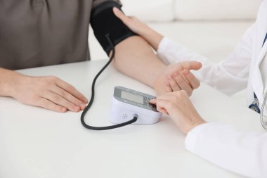 Doktor kan basıncını hastanedeki masada sphygmomanometre ile ölçüyor.