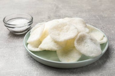 Gri masada pirinç kağıt parçaları ve tuz, yakın plan.