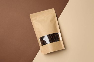 Arka planda kahve çekirdekleri olan stand-up torbası, üst görünüm.