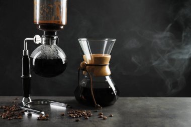 Sıcak içecek, fasulye ve cam kimya kahve makineli vakum kahve makinesi gri masada, yakın plan. Metin için boşluk