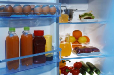 Farklı taze gıda ürünleri olan modern buzdolabı, yakın plan.