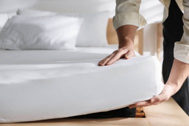 Yatakta yumuşak yatağa dokunan adam, yakın plan.