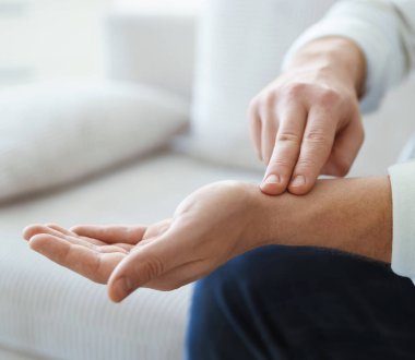 Adam içeride parmaklarıyla nabzını kontrol ediyor, yakın plan. Metin için boşluk