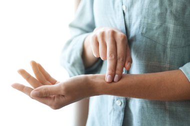 Kadın nabzını içeride kontrol ediyor, yakın plan.