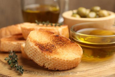 Tahtaya ekmek dilimleri, yağ, zeytin ve kekik, yakın plan.
