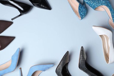 Açık gri arka planda, düz zeminde farklı güzel ayakkabıların çerçevesi. Metin için boşluk