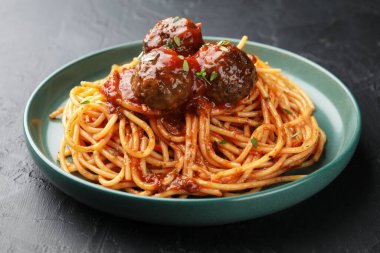 Köfteli lezzetli makarna, siyah desenli masa, yakın plan.