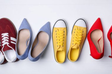 Beyaz ahşap zeminde farklı güzel ayakkabılar, düz yatış