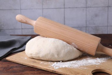 Hamur, merdane ve un ahşap masada, yakın plan.