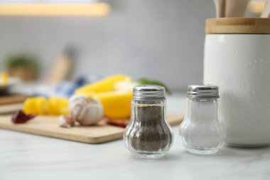 İçerideki beyaz mermer masada baharatlı tuzluk ve biberlikler, yakın plan. Metin için boşluk