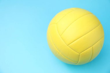Açık mavi zemin üzerinde bir voleybol topu. Metin için boşluk