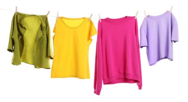 Çamaşır ipini beyaz arka planda tutarken farklı giysiler kuruyor