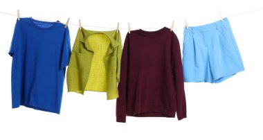 Çamaşır ipini beyaz arka planda tutarken farklı giysiler kuruyor