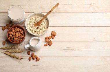 Yulaf gevreği, badem sütü ve açık ahşap masada fındık. Metin için boşluk