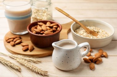 Yulaf gevreği, badem sütü ve açık ahşap masada fındık, yakın plan.