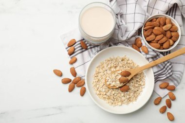 Yulaf gevreği, badem sütü ve fındıklar beyaz mermer masada, düz yatıyordu. Metin için boşluk