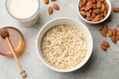 Yulaf gevreği, badem sütü, fındık ve bal gri masada, düz yatıyordu.