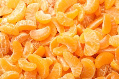 Arka plan olarak birçok olgun soyulmuş mandalina, üst görünüm