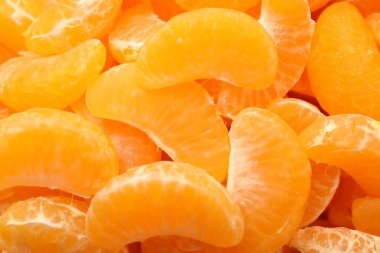 Arka plan olarak birçok olgun soyulmuş mandalina, üst görünüm