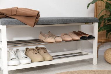 Beyaz duvarın yanında farklı ayakkabı, ceket ve çiçek depolarına yakın, yakın plan.