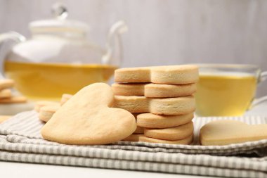 Lezzetli kalp şeklinde kurabiyeler ve çay, yakın plan.