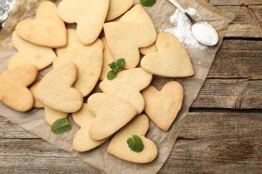 Nefis kalp şekilli kurabiyeler, nane ve pudra şekerli ahşap masa, düz uzanmış