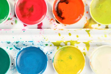 Arka plan olarak suluboya boyalar içeren palet, üst görünüm