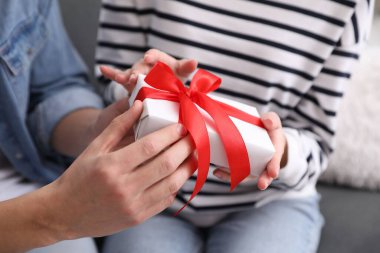 Sevgililer Günü. Genç adam kız arkadaşına hediye veriyor, yakın plan.