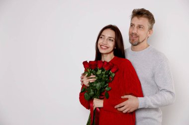 Hafif arka planda gül buketi olan mutlu çift, mesaj için yer var. Sevgililer Günü kutlaması