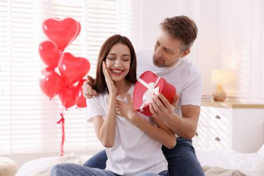 Sevgililer günü hediyesiyle sevgilisine sürpriz yapan mutlu bir adam.